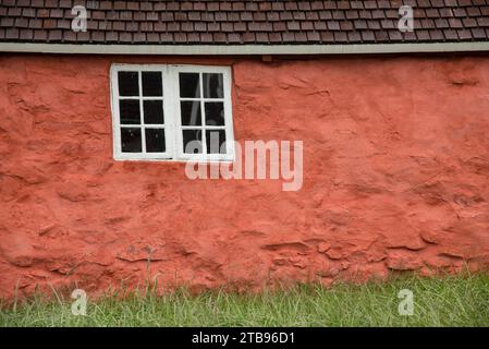 Altes Holzfenster in einem historischen Haus mit roten Steinmauern im Sisimiut Museum; Sisimiut, Grönland Stockfoto