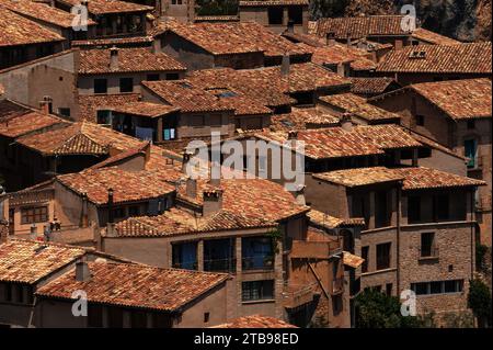 Dicht gepackte traditionelle Häuser mit Pfannendächern und gekachelten Kaminverkleidungen im mittelalterlichen Dorf Alquézar in den Ausläufern der Pyrenäen in Aragon, Spanien. Stockfoto