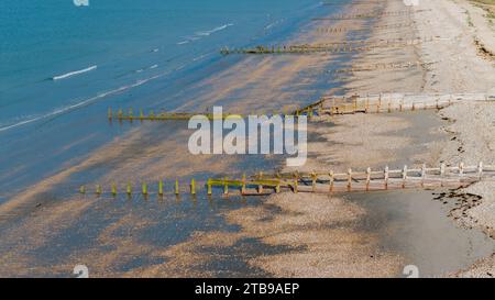 Bracklesham Bay an einem sonnigen Sommermorgen. Erhöhter Blick auf den tollen Strand und die Küstenlandschaft. Sträucher schützen den Strand vor Erosion. Stockfoto