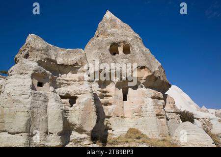 Nahaufnahme eines in die vulkanischen Felsformationen gehauenen Felsenhauses, eines Feenkamins, vor einem hellblauen Himmel in der Nähe der Stadt Goreme in Pigeon Val... Stockfoto