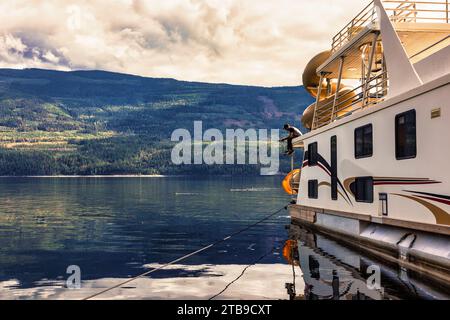 Mann, der eine Familie genießt, Hausbooturlaub und Angeln vom Deck des Hausbootes, während er am Ufer des Shuswap Lake parkt Stockfoto