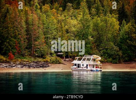 Ein Urlaubs-Hausboot, das im Herbst an der Küste des Shuswap Lake geparkt wurde; Shuswap Lake, British Columbia, Kanada Stockfoto
