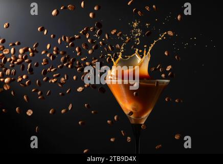 Espresso Martini-Getränk mit Spritzern und fallenden Kaffeebohnen auf schwarzem Hintergrund. Kopierbereich. Stockfoto