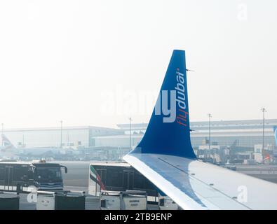 Dubai, Vereinigte Arabische Emirate - 12. Oktober 2023: Flugzeugflügel mit dem Logo von Fly Dubai Airlines über dem Dubai International Airport Stockfoto