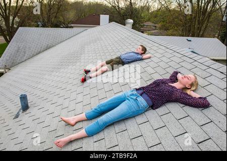 Bruder und Schwester lagen auf einem schindelförmigen Dach; Elkhorn, Nebraska, Vereinigte Staaten von Amerika Stockfoto