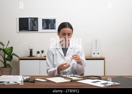 Virtuelle Verordnung: Weibliche Ärztin hält eine Flasche Pillen oder Vitamine, Telehealth-Beratung Stockfoto