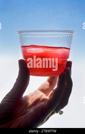 Frau Hand hält eine Portion Preiselbeersaft in einem Flugzeug; Phoenix, Arizona, Vereinigte Staaten von Amerika Stockfoto