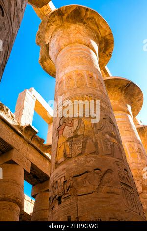 Nahaufnahme der Hieroglyphen auf den Säulen der Großen Hypostilhalle, die bis zum blauen Himmel im Karnak Tempelkomplex nahe L... Stockfoto