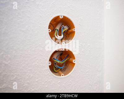 WAGO-Steckverbinder an den elektrischen Leitungen in einer hohlen Wandsteckdose. Installation von Steckdosen in einer Wohnung. Sanierung des Haushaltssystems. Stockfoto