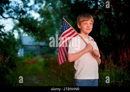 Ein junger, patriotischer Junge hält eine amerikanische Flagge; Lincoln, Nebraska, Vereinigte Staaten von Amerika Stockfoto