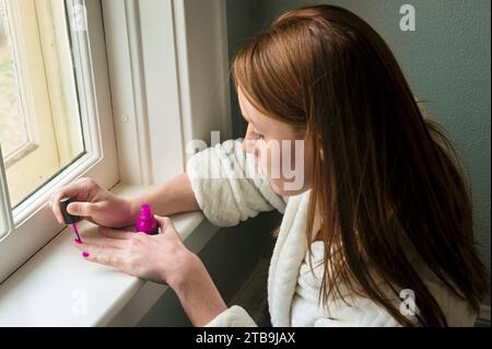 Junge Frau malt ihre Fingernägel; Lincoln, Nebraska, USA Stockfoto