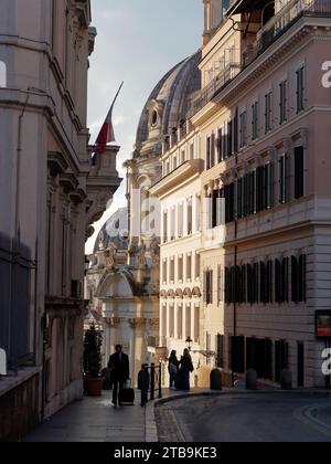 Fußgänger mit der Kuppel der Kirche des Allerheiligsten Namens Maria im Trajan Forum dahinter. Rom, Region Latium, Italien, Dezember Stockfoto