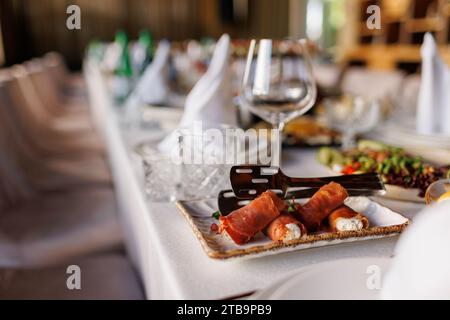 Organisierte Veranstaltung, festlicher Tisch mit Mahlzeiten, Vorspeise für Gäste bereit, dekoriert mit leeren Gläsern, Tellern, Serviette, Besteck. Einstellung Bankett f Stockfoto