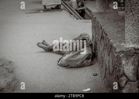 Schwarz-weiß-Foto eines armen Menschen, der auf der Straße in Afrika schläft Stockfoto