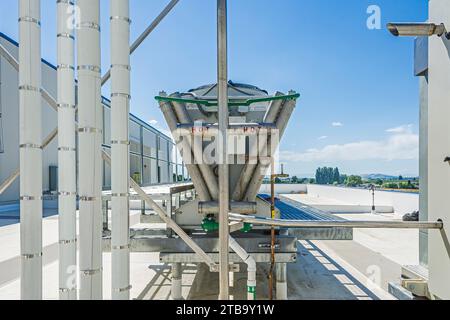 V-förmiges Ende des adiabatischen Kondensators auf dem Dach eines CO2-Kühllagers (Industriekühlung), von der Nähe des Kompressorgehäuses aus gesehen. Stockfoto