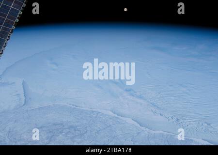 Blick aus dem Weltraum auf einen Vollmond, der über einer eisigen Hudson Bay im Norden Kanadas aufsteigt. Stockfoto