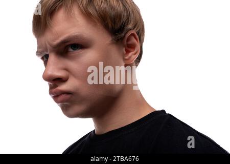 Kopffoto eines verdächtigen blonden Kaukasiers mit blonden Haaren, die unter seinen Augenbrauen schauen Stockfoto