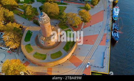 Hafen und Leuchtturm in Kołobrzeg, Polen. Foto mit einer Drohne am Anfang des Herbstes. Die plätschernde, blaue Ostsee. Stockfoto