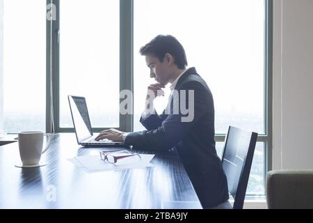 Geschäftsmann sitzt am Schreibtisch und arbeitet am Computer Stockfoto