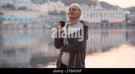 Eine Frau, Dame trinkt einen Kaffee und genießt den Sonnenuntergang. Stockfoto