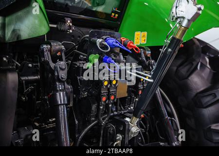 Rückansicht moderner landwirtschaftlicher Traktoren im Hangar. Hydraulische Anhängekupplung. Hydraulischer Hubrahmen. Hinterer Mechanismus zum Anbringen von gezogenen Geräten. Stockfoto