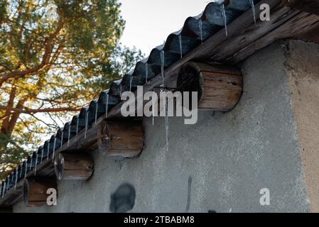 Eiszapfen hängen vom Blechdach Stockfoto