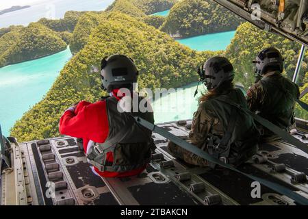 Palau. Dezember 2023. Flieger der 36th Expeditionary Airlift Squadron sitzen auf der Rampe eines C-130J Super Hercules, nachdem sie am 3. Dezember 2023 während der Operation Christmas Drop 2023 (OCD 23) Low-Altitude Bundle Drops auf der Insel Koror absolviert hatten. Die Funktionen, die während der OCD eingesetzt werden, sind eine einzigartige Methode der Bereitstellung, die für die Region geeignet ist. Coast Humanitarian Air Drop (TSCHAD) bringt die LCLA-Fähigkeit in die verschiedenen Umgebungen, die an vielen Orten im Pazifik zu sehen sind. Zusammen stellen TSCHAD und LCLA eine einzigartige Fähigkeit für humanitäre Hilfe und Katastrophenreaktion dar, die eine rasche Durchführung ermöglicht Stockfoto