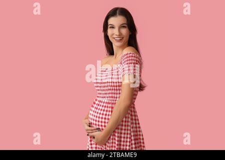 Junge Schwangere nach Impfung auf rosa Hintergrund Stockfoto