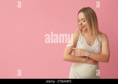 Junge Schwangere nach Impfung auf rosa Hintergrund Stockfoto