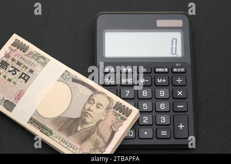 Japanische Gehaltsumschläge und Taschenrechner, die Banknoten werden auf Japanisch als "10.000 Yen" geschrieben. Stockfoto