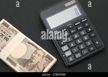 Japanische Gehaltsumschläge und Taschenrechner, die Banknoten werden auf Japanisch als "10.000 Yen" geschrieben. Stockfoto