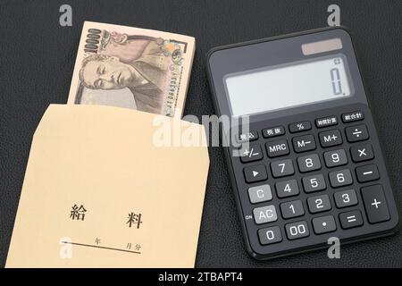 Japanischer Gehaltsumschlag und Taschenrechner, Übersetzung: Gehalt, die Banknoten werden auf Japanisch als '10.000 Yen' geschrieben. Stockfoto