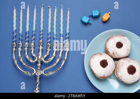 Flache Lay-Komposition mit Hanukkah-Menora auf blauem Hintergrund Stockfoto