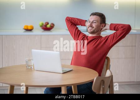 Charismatischer Happy Good man Freelancer, der zu Hause am Laptop arbeitet, glücklich über erfolgreiches Projektende Stockfoto