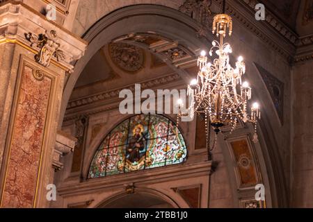 Kronleuchter beleuchtet, dekoriert und hängt in einer historischen alten Kathedrale mit selektivem Fokus, klassische Architektur. Stockfoto