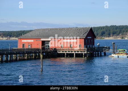 Coupeville, WA, USA - 14. November 2023; Rotes Gebäude an der Coupeville Wharf bei Flut in Penn Cove Stockfoto