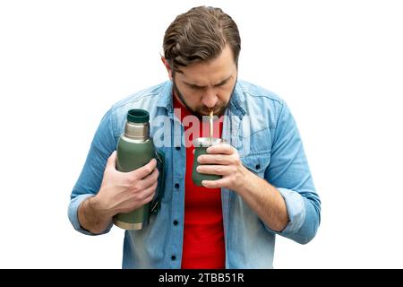 Junger Mann trinkt Kumpel, der die Thermoskanne im Arm trägt. Stockfoto