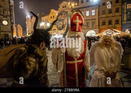 Prag, Tschechische Republik. Dezember 2023. Als Heiliger Nikolaus (C), Teufel (L) und Engel (R) gekleidet auf dem Altstädter Ring in Prag. Die Tradition des Heiligen Nikolaus in Tschechien, genannt Svaty Mikulas, wird in vielen europäischen Ländern gefeiert. Es wird vermutet, dass der Heilige Nikolaus kommt, um seinen Tag zu feiern und vor Weihnachten abreist. Künstler spazieren durch das Stadtzentrum und wünschen den Menschen frohe Weihnachten und belohnen Kinder mit kleinen Geschenken. Quelle: SOPA Images Limited/Alamy Live News Stockfoto