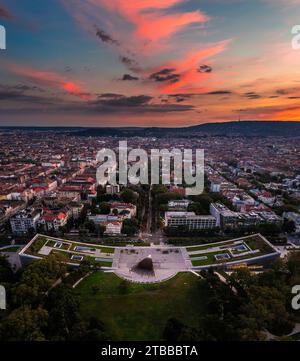 Budapest, Ungarn - Panoramablick auf das Ethnographische Museum im Stadtpark mit der Skyline von Budapest im Hintergrund und farbenfroher Sonnenuntergang Stockfoto