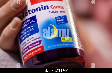 Leipzig, Deutschland. Dezember 2023. ABBILDUNG - Ein Kind hält eine Packung Gummibären, die Melatonin enthalten. Diese Nahrungsergänzungsmittel sollen Kindern helfen, schneller einzuschlafen. (Zu dpa 'gefährlicher Trend: Kinderärzte warnen vor Melatonin als Schlafmittel') Credit: Jan Woitas/dpa/Alamy Live News Stockfoto