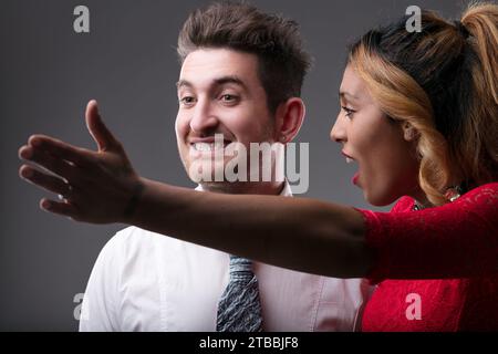 Elegantes Paar in einem angespannten Moment; ihr offenmundiger Mahnsinn dominiert Stockfoto