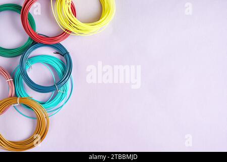 Blick über dem Tisch mit bunten Kunststoffschnüren für modernen 3D-Stift. Hobby, Spielzeug und handwerkliche Texturen und Hintergründe. Kopierbereich für Text Stockfoto