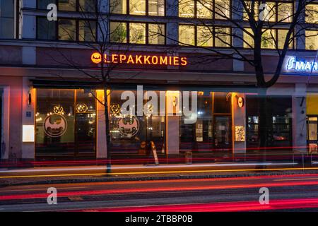 Tauchbar und Musikstätte Lepakkomies in Helsinginkatu 1 nach Einbruch der Dunkelheit mit leichten Pfaden vorbeifahrender Fahrzeuge im Bezirk Harju in Helsinki, Finnland Stockfoto