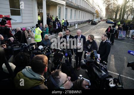 Der Anwalt Aamer Anwar liest eine Erklärung von seinem Telefon, da er Mitglieder der COVID-Hinterbliebenen sowie andere Kernteilnehmer wie Long COVID, (von links nach rechts) Hannana Siddiqui, Anna Louise Marsh-Rees, Aamer Anwar, Alan Inglis, Natalie Rogers und Craig Court steht. außerhalb der COVID-19-Untersuchung des Vereinigten Königreichs im Dorland House in London, wo der ehemalige Premierminister Boris Johnson während seiner zweiten Untersuchung (Modul 2) Beweise vorlegen soll, in denen Kernentscheidungen und politische Governance des Vereinigten Königreichs untersucht werden. Bilddatum: Mittwoch, 6. Dezember 2023. Stockfoto