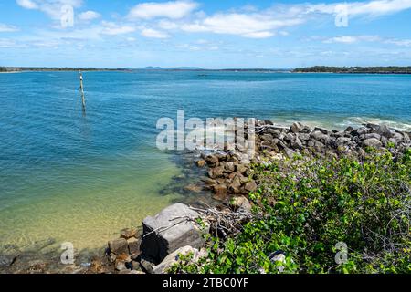 Felswand und blaues Wasser an der Mündung des Clarence River, Yamba, New South Wales Stockfoto