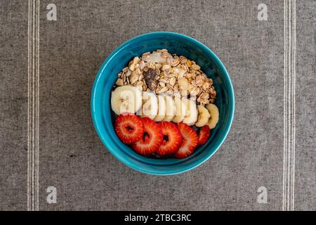 Ein Bild aus der Vogelperspektive einer Schüssel Acai-Eis mit frischem Obst und Haferflocken. Stockfoto