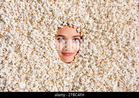 Hochwinkel-Ansicht Porträt des fröhlichen netten Mädchens haben gute Stimmung Gesichtsstab innen voll mit Popcorn Hintergrund Stockfoto