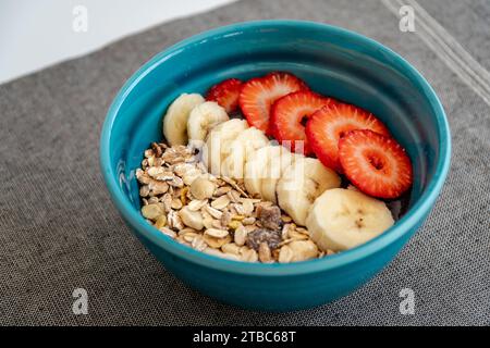 Ein Nahbild einer Schüssel frisches Acai-Eis mit gesundem Obst und Haferflocken. Stockfoto