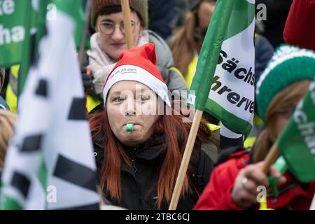 Dresden, Deutschland. Dezember 2023. Teilnehmer einer von der bildungsgewerkschaft Gew organisierten Kundgebung stehen auf dem Carolaplatz. Lehrkräfte und Universitätsangestellte in Sachsen wurden erneut zu einem Warnstreik aufgerufen. Unter anderem fordern die Gewerkschaften eine Gehaltserhöhung von 10,5 Prozent, aber mindestens 500 Euro. Quelle: Sebastian Kahnert/dpa/Alamy Live News Stockfoto