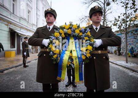 Kiew, Ukraine. Dezember 2023. Ukrainische Ehrenwachen tragen einen Blumenkranz, während Präsident Wolodymyr Zelenskyj gefallene Verteidiger am Tag der Streitkräfte an der Mauer der Erinnerung bei St. Michaels goldene Kathedrale, 6. Dezember 2023 in Kiew, Ukraine. Quelle: Pool Photo/Ukrainische Präsidentenpresse/Alamy Live News Stockfoto